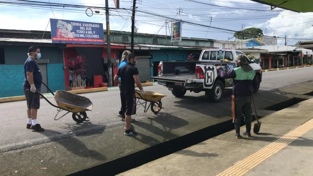 Hombres usando carretillo y un pick up automóvil