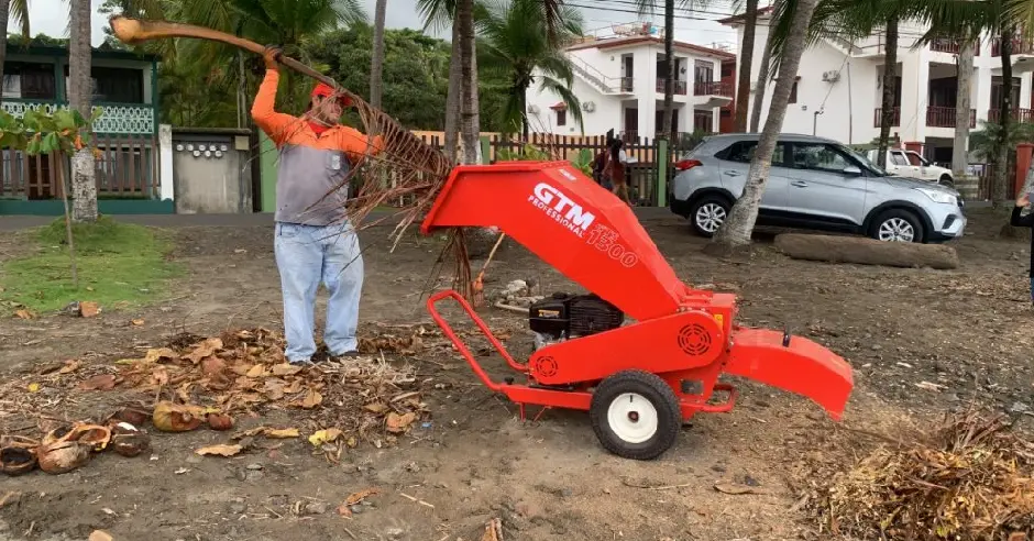 Hombre limpiando playa usando máquina trituradora